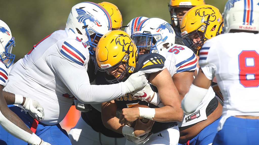 The Blue Dragon defense swarms a Highland ball carrier during Hutchinson's 20-7 win over the Scotties on Saturday at Highland. (Photo courtesy Billy Watson/The Hutchinson News)