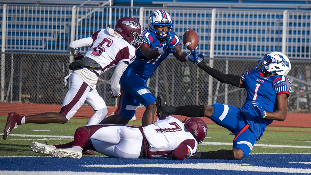 Malik Benson (11) eyes a Hail Mary pass originally tipped by Cortez Braham (1) and catches a 56-yard touchdown on the final play of the first half in No. 5 Hutchinson's 66-34 Salt City Bowl victory over No. 8 Hinds on Saturday at Gowans Stadium. (Andrew Carpenter/Blue Dragon Sports Information)