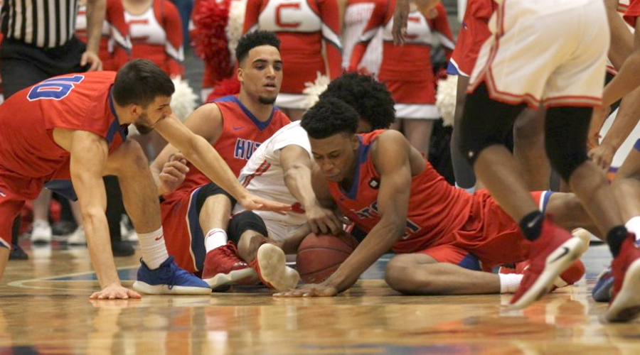 Malique Jacobs crashes to the floor to go after a ball with James Rojas and Tyler Brown close by. Hutchinson advanced to the Region VI finals for the seventh-straight year with a 94-89 double-overtime win over No. 3 Coffeyville on Monday at Hartman Arena in Park City. (Bre Rogers/Blue Dragon Sports Information)