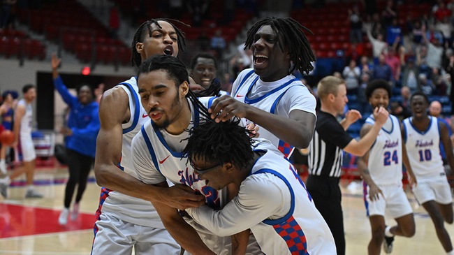 Blue Dragon teammates swarm Kamryn Thomas, who hit a game-winning overtime buzzer beater in Hutchinson's 88-87 Region VI Tournament quarterfinal victory over Garden City on Tuesday at the Sports Arena. (Andrew Carpenter/Blue Dragon Sports Information)
