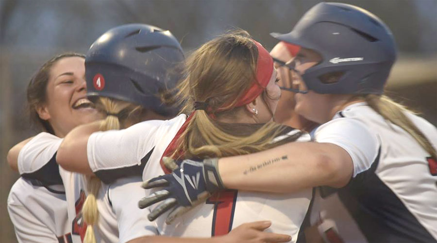 Blue Dragon teammates congratulate Shelby Felvus (No. 4) after scoring the game-winning run in the bottom of the ninth in a 7-6 victory over Dodge City on Friday at Fun Valley. (Sammi Carpenter/Blue Dragon Sports Information)